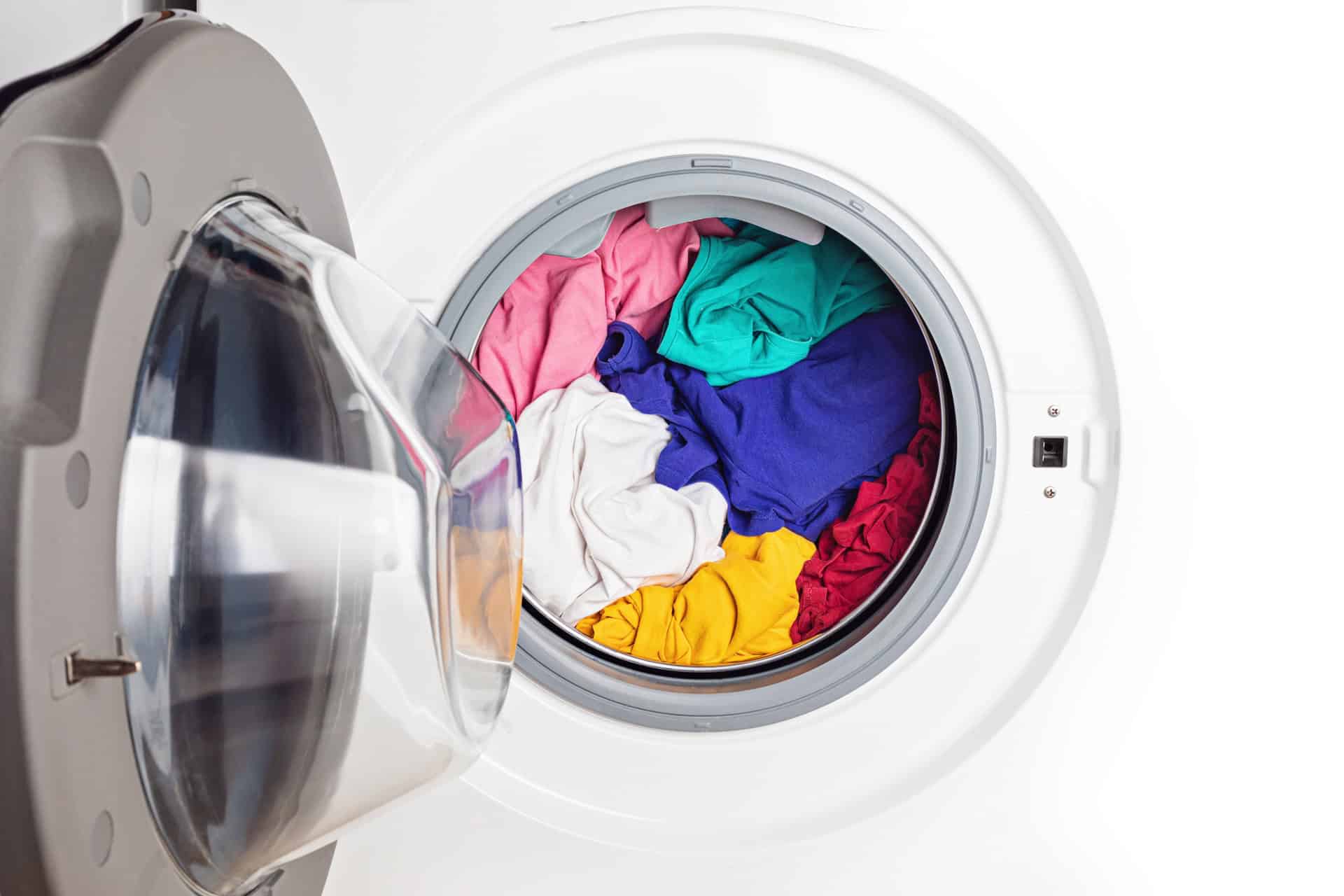 Front-loading washing machine with its door open, showing a mix of colorful clothes inside ready for washing.